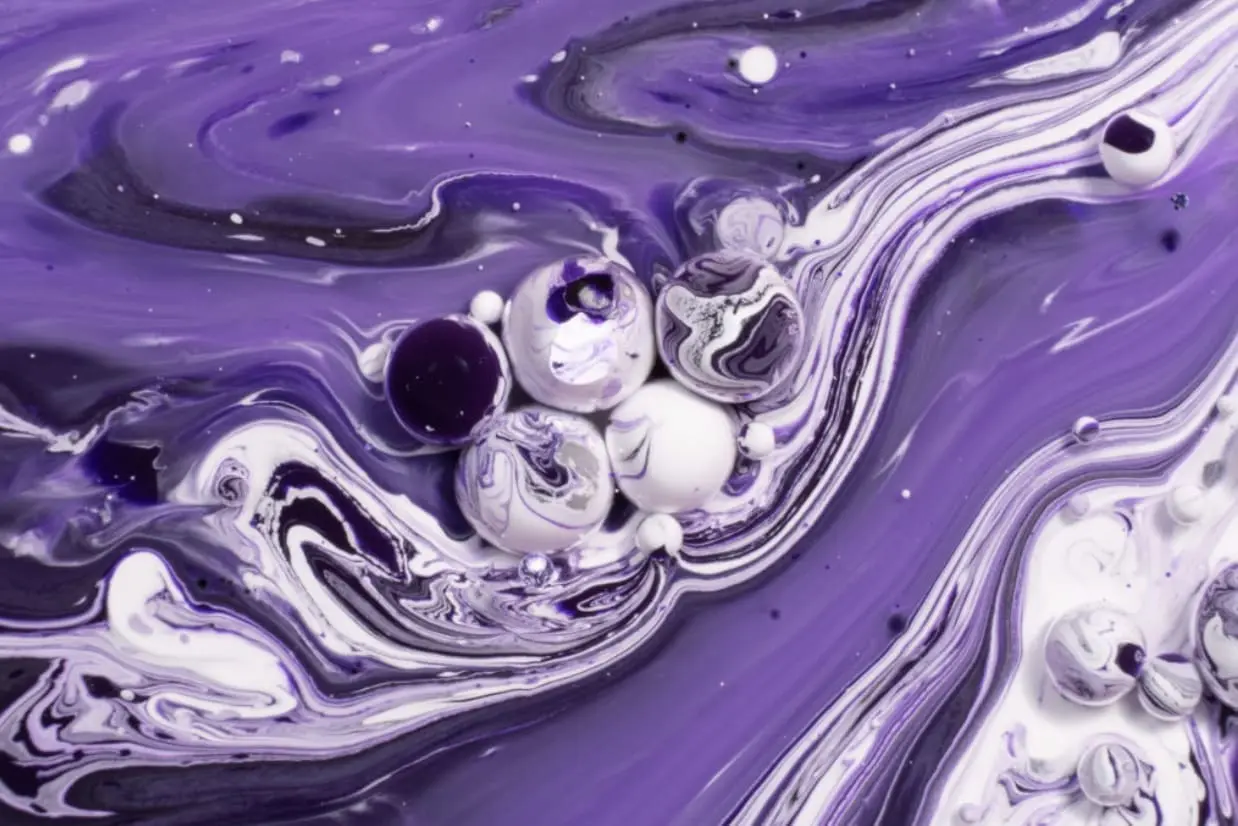 Abstract alcohol ink art featuring swirling purple and white patterns with spherical shapes, representing a creative workshop by local artist Sandy Fritz at Gulf Waters Beach Front RV Resort.