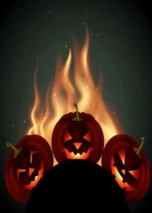 Three carved Halloween pumpkins glowing in front of a bonfire, symbolizing the Spooky Beach Bonfire event at Gulf Waters Beach Front RV Resort.
