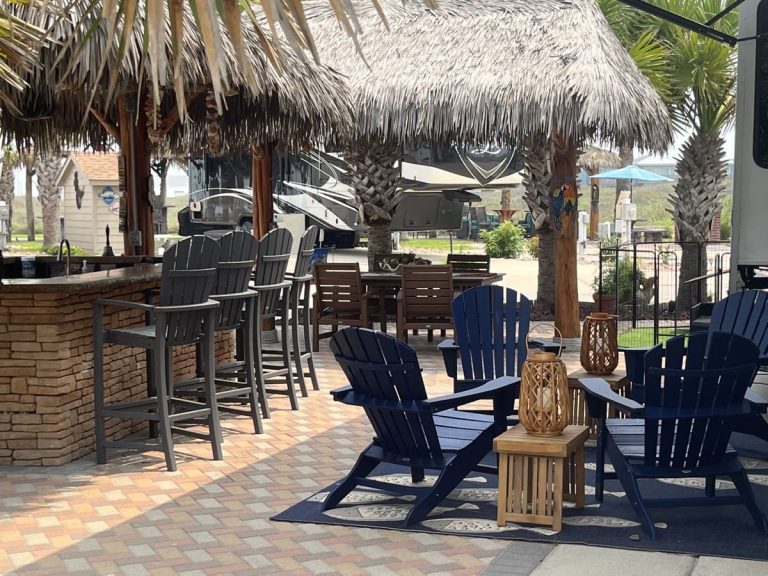 Relaxing outdoor patio with Adirondack chairs and tiki hut at Gulf Waters.