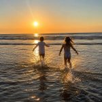 Children playing in the ocean at sunset at Gulf Waters Beach Front RV Resort.