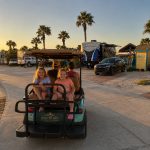 Children riding in a golf cart at Gulf Waters Beach Front RV Resort.