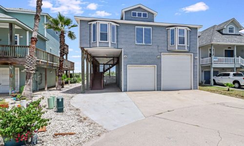 Beach house exterior at Gulf Waters Beach Front RV Resort, featuring modern design, palm trees, and proximity to Mustang Island's sandy shores.