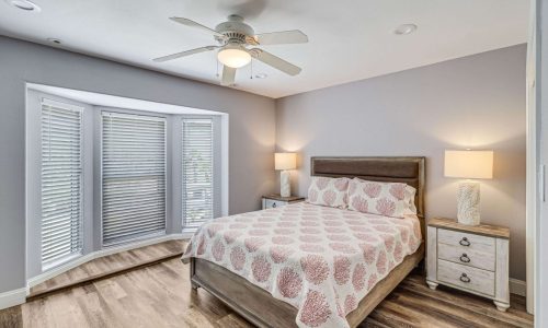 Cozy bedroom at Gulf Waters Beach Front RV Resort with large windows and modern decor.