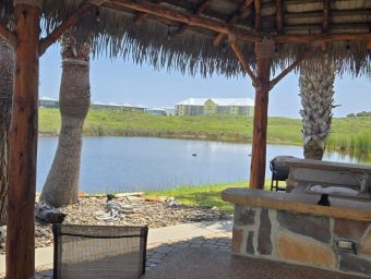 Scenic view of Gulf Waters Beach Front RV Resort with water and palm trees.