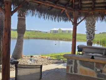 Scenic view of Gulf Waters Beach Front RV Resort with water and palm trees.
