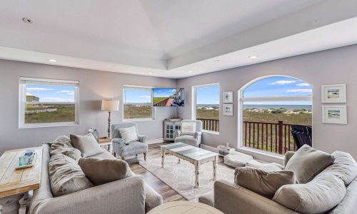 Cozy beach house interior with modern furnishings, large windows showcasing coastal views, and a welcoming atmosphere, perfect for a vacation at Gulf Waters Beach Front RV Resort.