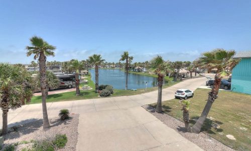 Scenic view of Gulf Waters Beach Front RV Resort with palm trees and water.