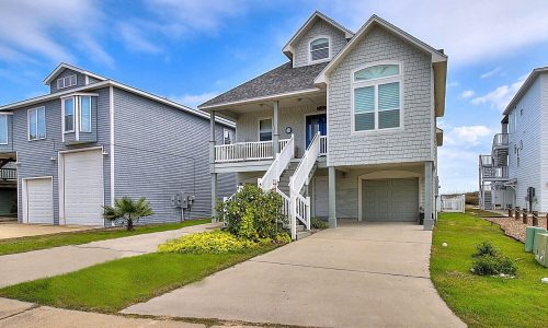 Beach house exterior at Gulf Waters Beach Front RV Resort, featuring modern design, front steps, and nearby greenery, ideal for vacation rentals near Mustang Island's sandy beaches.