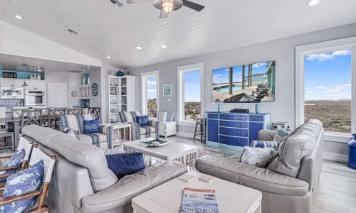 Modern beach house interior at Gulf Waters RV Resort, featuring comfortable seating, coastal decor, large windows with scenic views, and a stylish kitchen area, ideal for family vacations and group getaways on Mustang Island.