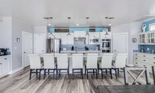 Modern kitchen at Gulf Waters Beach Front RV Resort with white cabinets and blue backsplash.