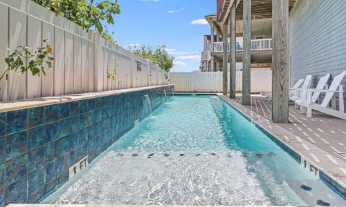 Private swimming pool at Gulf Waters Beach Front RV Resort, featuring clear water, tiled edges, and surrounding lounge chairs, ideal for a relaxing beach getaway.