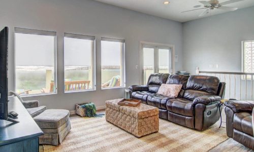 Spacious living room at Gulf Waters Beach Front RV Resort with large windows and comfortable seating.