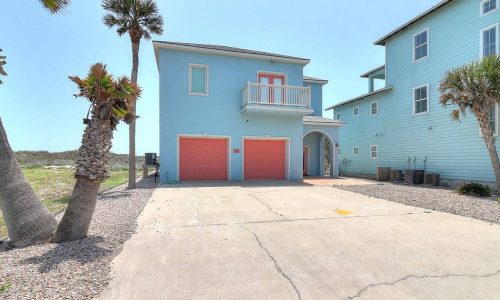 Beachfront RV resort with colorful buildings and palm trees.