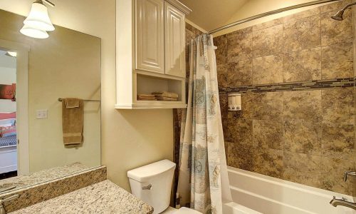 Bathroom with bathtub, shower, and granite countertop at Gulf Waters RV Resort.