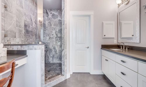 Modern bathroom with gray marble shower, white cabinetry, and stylish fixtures, showcasing luxurious accommodations at Gulf Waters Beach Front RV Resort.