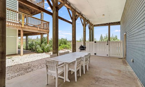 Beachfront RV resort patio with dining table and grill, scenic views, and wooden deck.