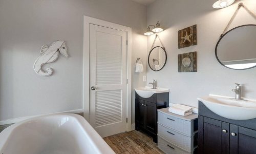 Modern bathroom at Gulf Waters Beach Front RV Resort with dual sinks and nautical decor.