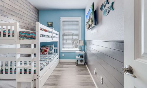 Cozy beach house interior with bunk beds, modern decor, and coastal-themed accents, ideal for family vacations at Gulf Waters Beach Front RV Resort.
