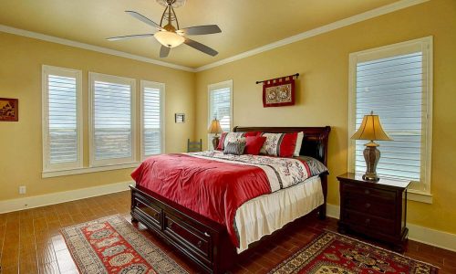 Cozy bedroom at Gulf Waters Beach Front RV Resort with large windows and warm decor.