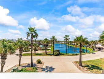 Scenic view of Gulf Waters Beach Front RV Resort with palm trees and water.