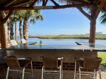 Scenic view of Gulf Waters Beach Front RV Resort with palm trees and water.