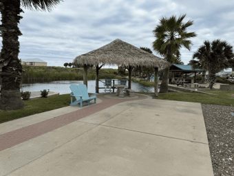 Beachfront RV resort with shaded gazebo, palm trees, and water views.