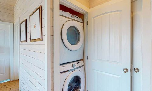 Laundry area with stacked washer and dryer at Gulf Waters Beach Front RV Resort.