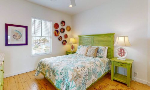 Bright bedroom with green furniture and ocean-themed decor at Gulf Waters.