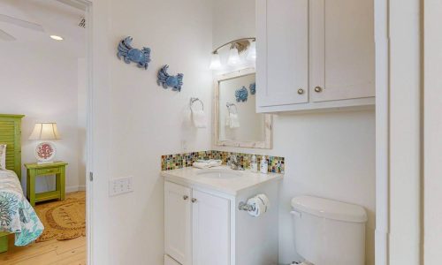 Cozy bathroom at Gulf Waters Beach Front RV Resort with white cabinetry and colorful tile.