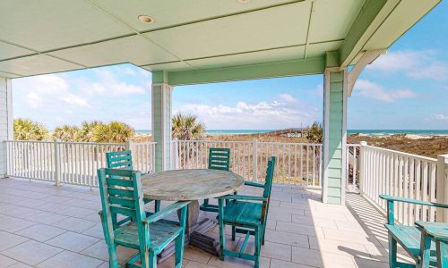 Beachfront deck with table and chairs at Gulf Waters RV Resort.