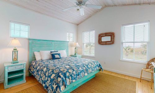 Bright bedroom with beach-themed decor and large windows at Gulf Waters Resort.