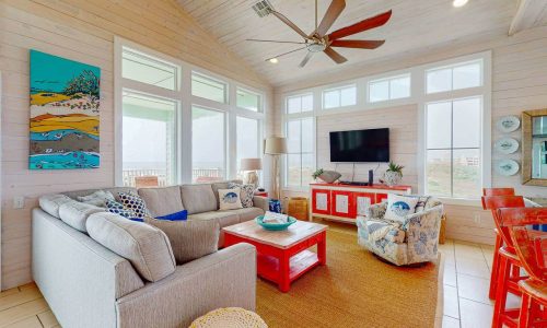 Bright living room with large windows, beach decor, and modern furnishings at Gulf Waters RV Resort.