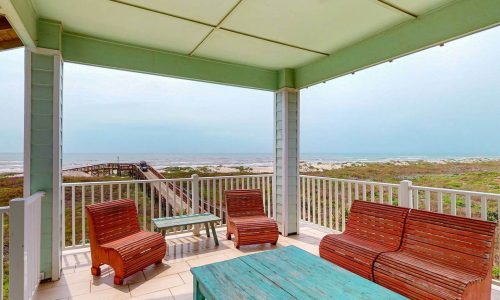 Beachfront porch with seating overlooking Gulf Waters beach and ocean.