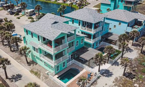 Colorful beach house with pool and palm trees at Gulf Waters Resort.