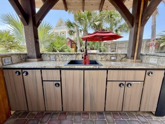 Outdoor kitchen at Gulf Waters Beach Front RV Resort with sink and cabinets.