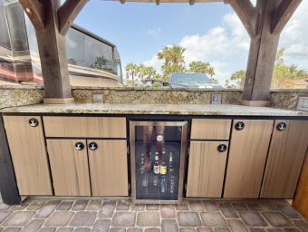Outdoor bar with cabinets and a mini fridge at Gulf Waters Beach Front RV Resort.